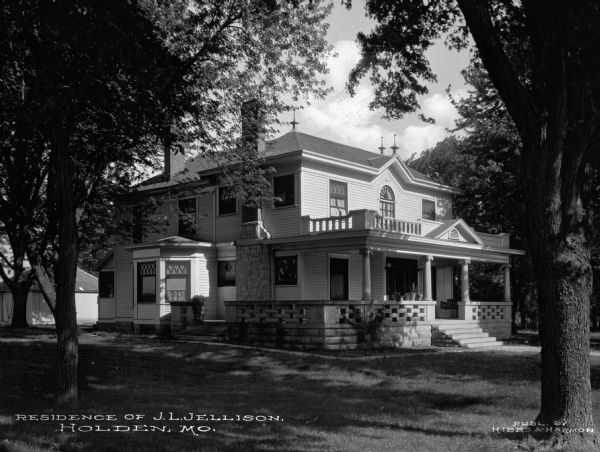 Residence of J.L. Jellison. View of home and tree-shaded yard. Caption reads: "Residence of J.L. Jellison. Holden, Mo."