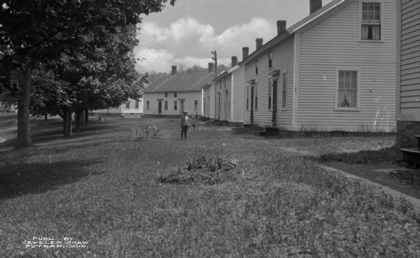 Children standing in the rear of a row of homes.