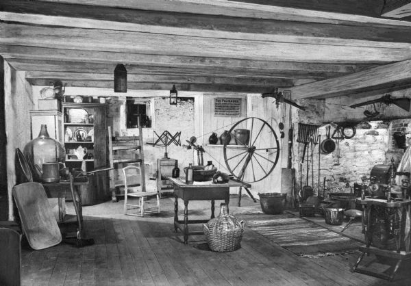 View of the slave kitchen in the Judson House. Built circa 1750 by Captain David Judson, the kitchen features a large brick hearth and fireplace with tools and cooking implements. Two rifles hang above the hearth. Kitchen also features spinning wheels, a yarn swift, tables, chairs, cupboards with tableware and various household tools and items. Sign on far wall reads: "The Palisades David." The home still stands and is a museum today.