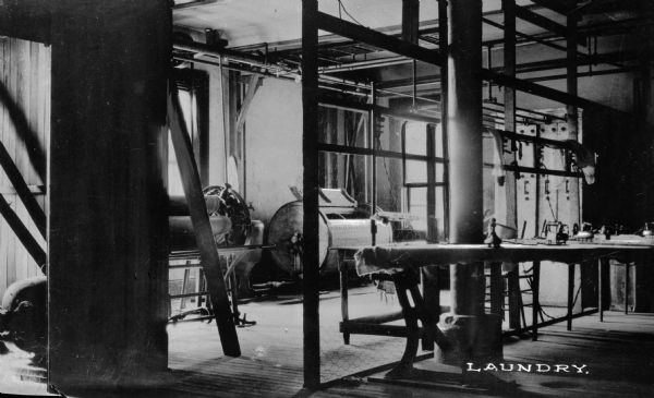 The laundry machinery at the Pythian Orphans' Home with irons sitting on ironing boards. Caption reads: "Laundry."
