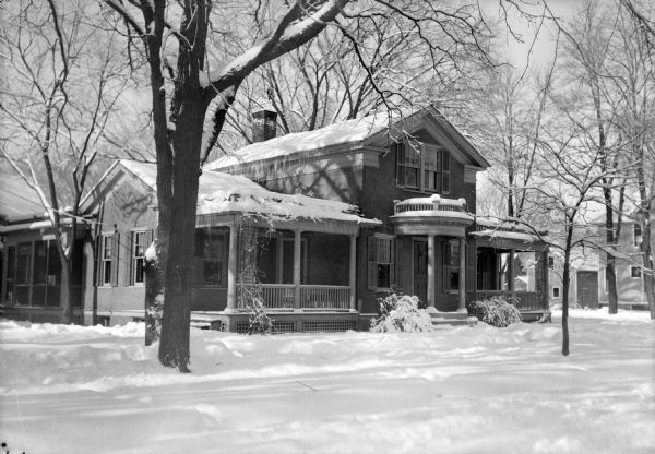 View from street of the home of Ephraim Burt and Alice Kent Trimpey, 719 Oak Street, after a snowfall. The classical revival style house has symmetrical wings with porches and a columned front entrance.