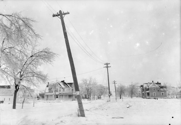 A street scene following an ice storm, possibly March 2, 1922. Utility poles are leaning and wires have been brought down by the weight of the ice.
