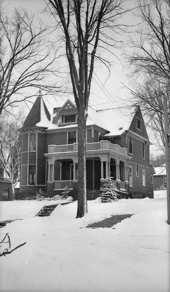 View from street of the home of George Snyder at 1219 Ash Street. It is a large wooden Queen Anne-style house with a columned front porch and a corner tower with turret.