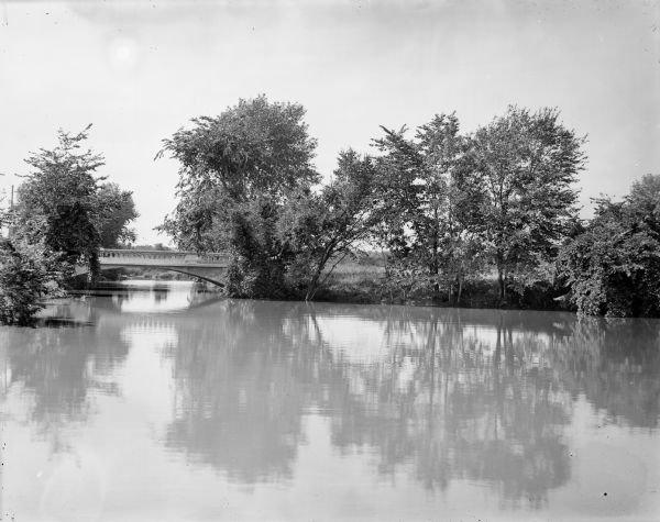 A view of high water on a river, possibly the Baraboo River, in a rural setting.
