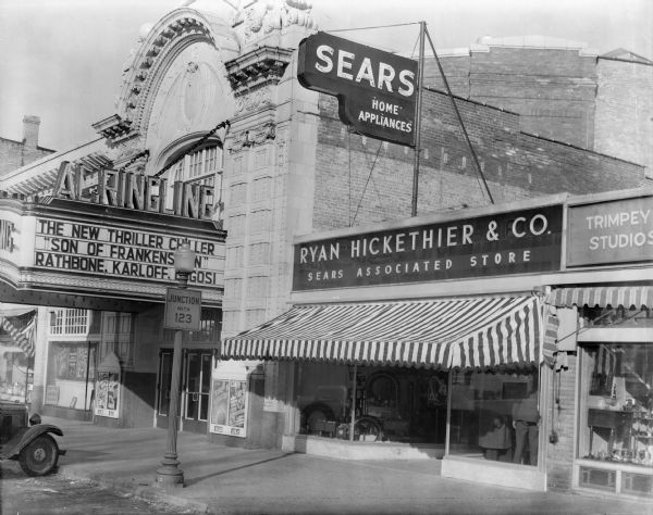 Fourth Avenue, showing the ornate Al. Ringling Theatre, Ryan Hickethier & Co, "A Sears Associated Store," and a portion of the Trimpey Studios storefront. "Son of Frankenstein" is playing at the theatre.