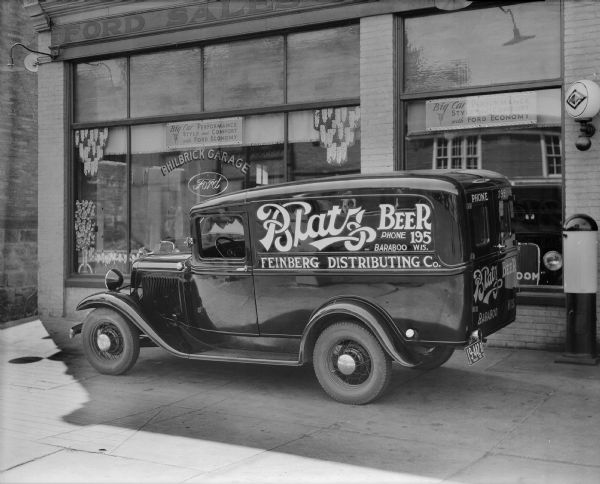A Ford "sedan delivery" truck owned by Feinberg Distributing Co. of Baraboo is parked in front of the Philbrick Ford Garage at 207 Third Avenue. "Blatz Beer" has been painted on the side of the truck.