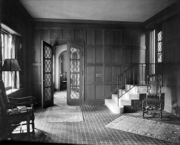 A tiled hall area in the 1928 addition to the home of William Llewellyn and Zona Gale Breese. A small stairway is on the right. The walls are wood paneled.