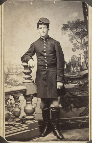 Full-length carte-de-visite portrait in front of a painted backdrop of William Hormusen, 1st Wisconsin Heavy Artillery.