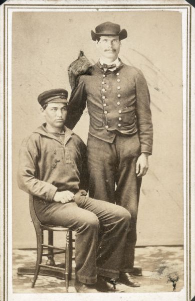 Seated carte-de-visite portrait of Private Henry C. Stafford, Company I, 4th Wisconsin Cavalry, and, standing on his left side, 1st Lieutenant Issac N. Earl, Company D, 4th Wisconsin Cavalry.