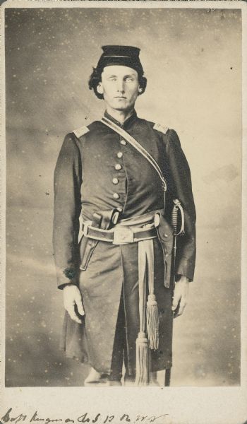 Three-quarter-length carte-de-visite portrait of Captain Newton H. Kingman, Company I, 13th Wisconsin Infantry, wearing full uniform with sidearm and sword on right side.