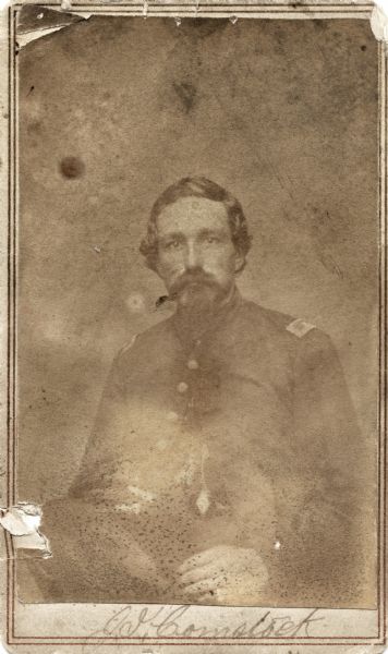 Seated carte-de-visite portrait of Lieutenant Julius I. Comstock, Company F, 16th Wisconsin Infantry.