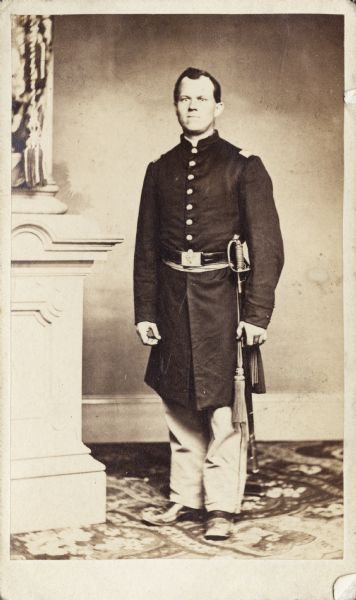 Full-length carte-de-visite portrait of Captain Charles Witte from Company E of the 27th Wisconsin Infantry, standing in uniform with sword on his left side.