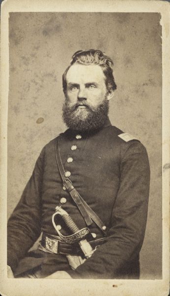 Seated waist-up carte-de-visite portrait of Captain Alexander Ahab Arnold, Company C, 30th Wisconsin Infantry, sitting with his sword at his side.