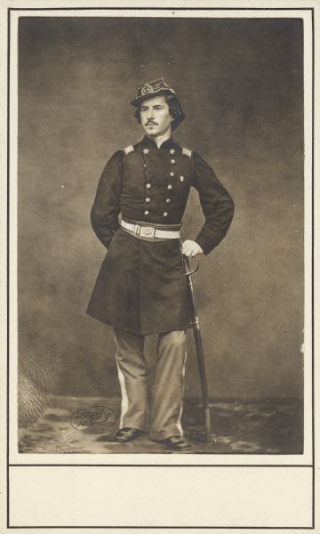 Full-length carte-de-visite portrait of Colonel Elmer E. Ellsworth, F & S, 11th New York Infantry, in full Union uniform, leaning on a sword. He was born in Malta, New York, but moved to Chicago, where he worked as a law clerk. He was also close to President Lincoln and his family. He was killed on May 24, 1861 in Alexandria, Virginia, while he and a few others went to remove a Confederate flag. He was succeeded by Lieutenant Colonel Farnham. 