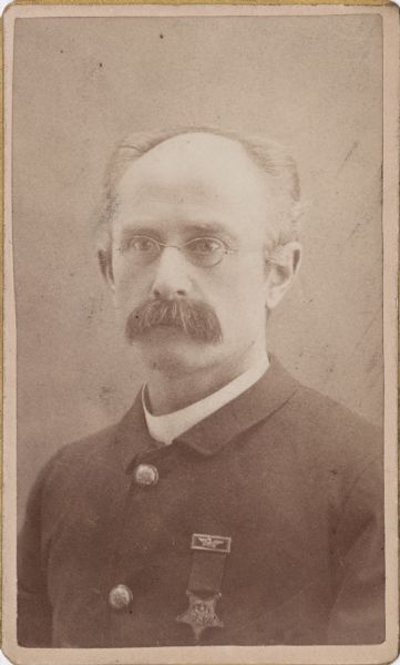 Quarter-length carte-de-visite portrait of 1st Lieutenant Charles H. Meyerhoff, Company E, 14th Indiana Infantry, wearing eyeglasses and a badge for the Grand Army of the Republic (GAR).