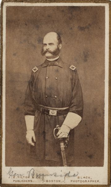 Three-quarter length carte-de-visite portrait of General Ambrose Burnside, wearing gauntlet gloves and holding a sword.