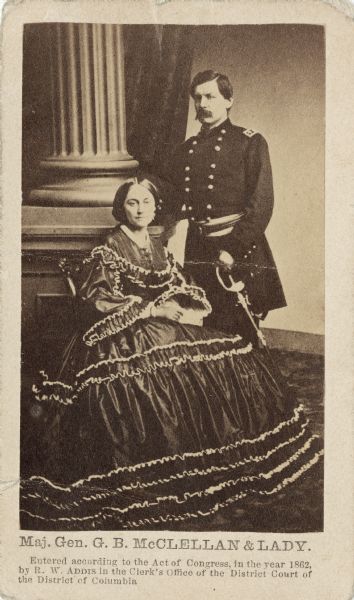 Carte-de-visite portrait of Major General George B. McClellan standing, with his wife, Ellen Mary Marcy, seated.