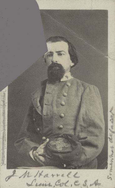 Waist-up carte-de-visite portrait of Confederate Lieutenant Colonel John M. Harrell of Harrell's Battalion in the Arkansas Cavalry, wearing a uniform and holding a hat in his lap.