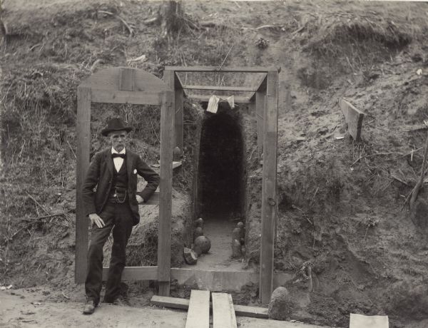 Cave in a hillside occupied by the Lewis family from May 18 to July 4, 1863, during the Civil War siege of Vicksburg.  Hundreds of other caves in the vicinity were similarly occupied by citizens of Vicksburg, but this is the only one which, by 1902, remained as an exhibit.  In front is T.E. Lewis who was 14 years old at the time of the siege in 1863.