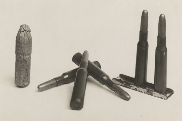 Display of paper-wrapped rifle-musket cartridges, about .58 caliber, of the type used in the Civil War, compared with 30-40 U.S. rifle cartridges.