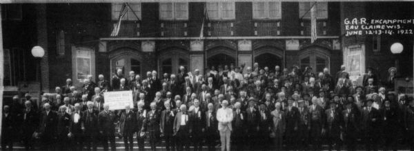 Outdoor group portrait of Union veterans standing on the steps in front of a building, June 12-14.