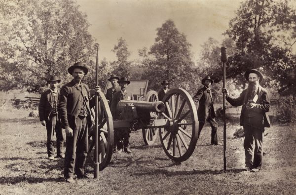 Group portrait of unidentified Civil War veterans around a cannon. Probably a Grand Army of the Republic reunion.