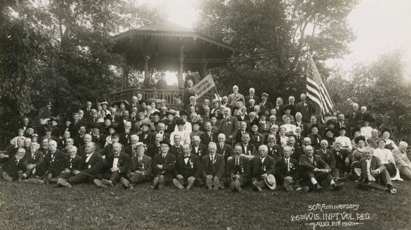 Outdoor group portrait of the fiftieth annual reunion of the 26th Regiment of Wisconsin Volunteer Infantry at Whitefish Bay.