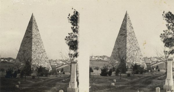 An albumen stereograph of a monument to the Confederate dead, in the shape of a stone pyramid with steeply pitched sides.