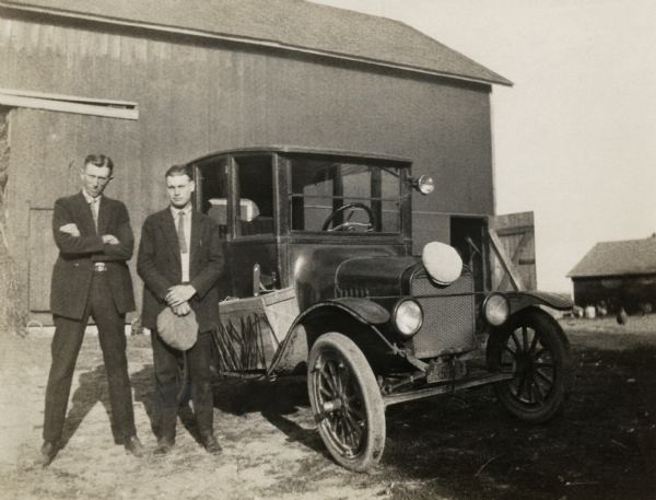 Mervin Kittleson and Floyd Quinney standing in front of a barn and next to a Ford Model T just before they embark for a trip to California.