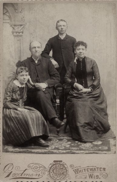 Studio portrait in front of a painted backdrop of James and Mary Bray Holloway and their children, Lizzie and Will.