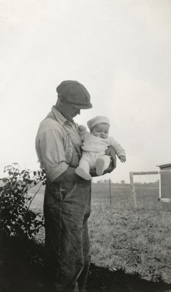 Richard Quinney as a baby held by his father, Floyd Quinney, in the family's farmyard.