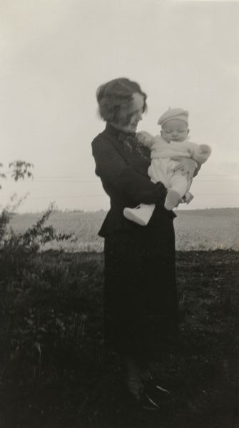 Baby Richard Quinney held by his mother, Alice Quinney, in the farmyard.