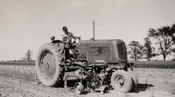 Yound Richard Quinney operating a tractor to cultivate corn.