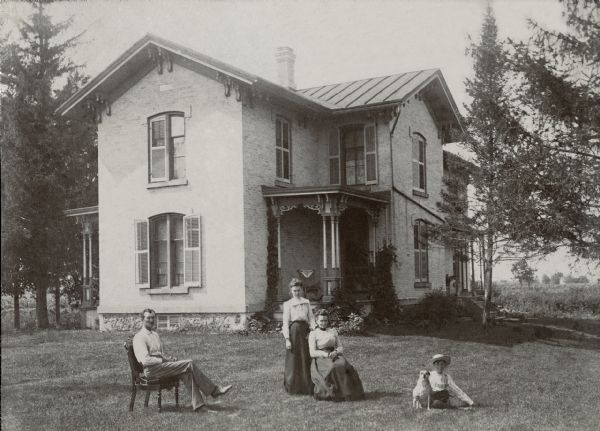 Family portrait of Charles Taylor, his wife, Ellen Wishart, and their two children taken on the lawn in front of their house.  Lorena Taylor, standing beside her mother, was Richard Quinney's maternal grandmother.