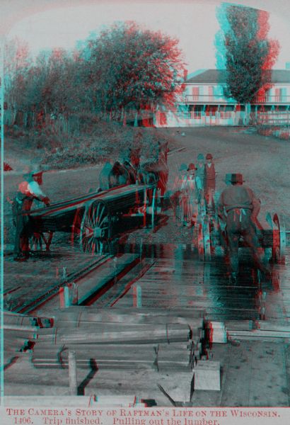 Stereograph of men unloading lumber off a raft. A man at the left loads lumber onto a horse-drawn wagon while a man in an apron holds the horses. There is a boy standing in the center. On the right a man loads lumber onto a second wagon. The rafts loaded with lumber are in the foreground. There is a large building on a hill in the background.