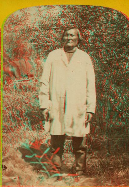 Stereograph of Ta-vah-puts, Chief of the U-in-tah Utes, standing in a field.
