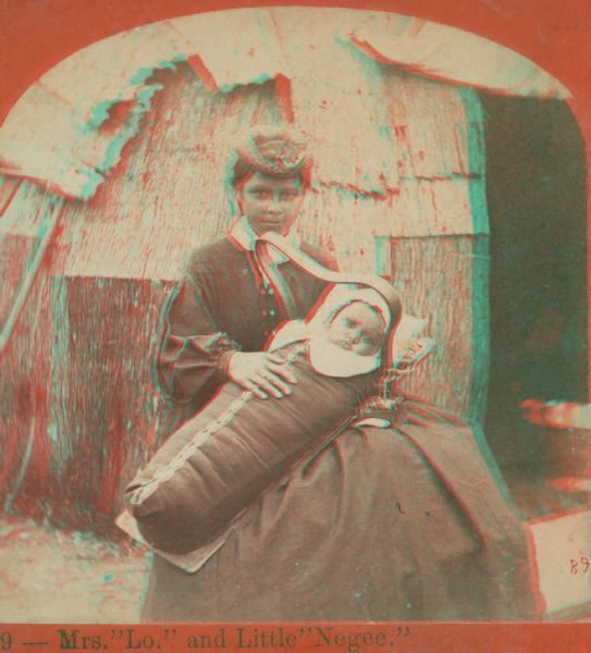 Stereograph portrait of Mrs. Lo, seated in front of a traditional dwelling, holding her infant Little Negee.