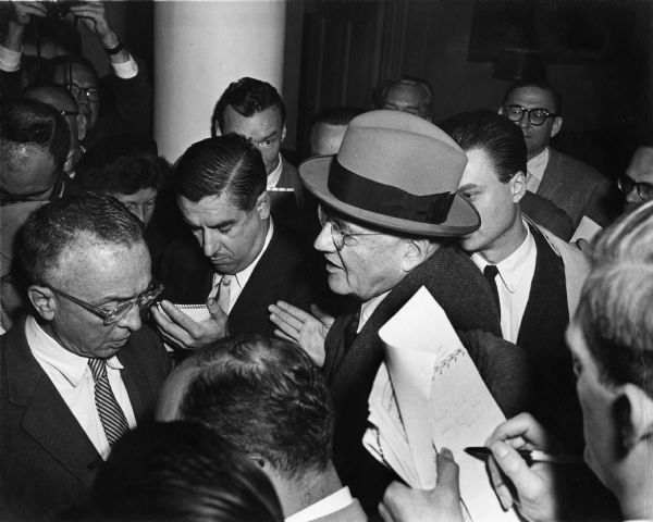 Reporters crowd around Secretary of State John Foster Dulles. To Dulles' right is longtime White House correspondent Merriman Smith.