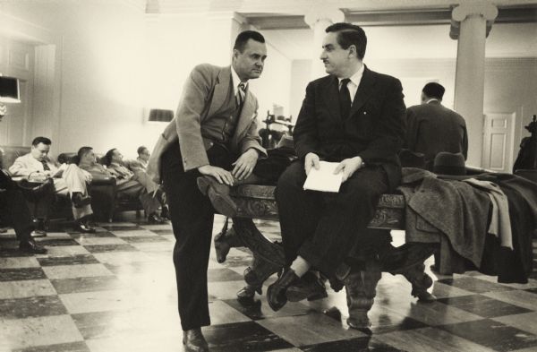 Merriman Smith, perched on a table with Dayton Moore in the press lounge. They are two correspondents who covered the White House.
