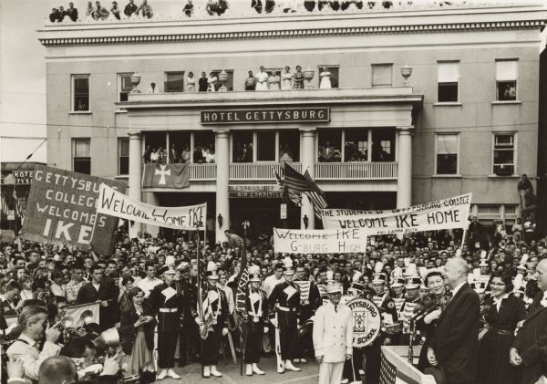 President and Mrs Eisenhower stand on a platform at the lower right to speak to the citizens of Gettysburg, Pennsylvania, who had turned out to greet him. Eisenhower planned an extended visit to his farm located there to recover from his recent heart attack.