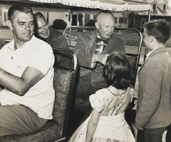 President Eisenhower greets the children of reporter Merriman Smith at his farm in Gettysburg, Pennsylvania. The photograph is undated, but as Christian Herter is riding with Eisenhower and he became secretary of state in 1959, it was likely taken 1959-1960.