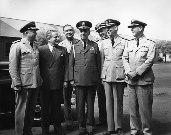 Fleet Admiral William D. Leahy (center) posed with several other World War II naval officers: (far left) Rear Admiral Ross McIntyre, personal physician to the President, (and beginning third from the right) Rear Admiral Chester Wood, Rear Admiral Wilhelm Friedell, and Rear Admiral Wilson Brown. The men on either side of Leahy are unidentified. Leahy, who served as military chief of staff to President Roosevelt during World War II and who was promoted to fleet admiral in 1944, was the first officer to hold a five-star rank. Leahy was raised in Ashland, Wisconsin.