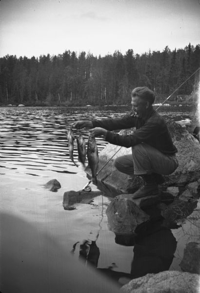 Sigurd F. Olson, displaying his catch during a family vacation in the Quetico-Superior region.