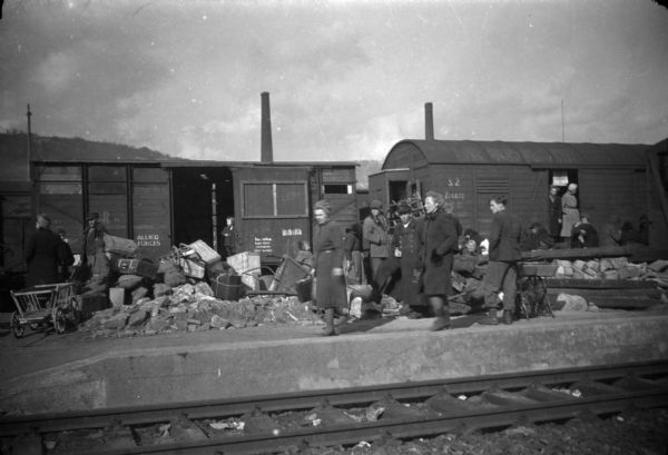 A snapshot of postwar refugees in Berlin traveling by railroad boxcar.