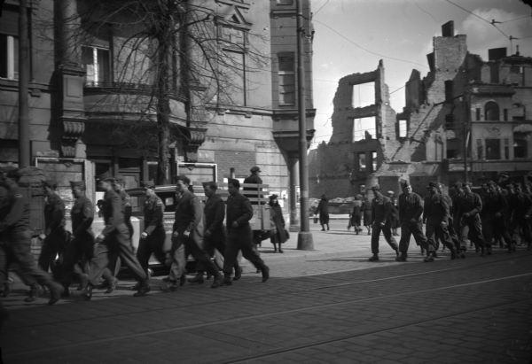 Conservationist Sigurd F. Olson, who was on a special military teaching assigment, took this picture of U.S. troops in Berlin marching to his lecture. Bombed buildings are visible in the background.