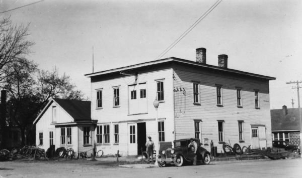Exterior view of the blacksmith shop of Christ M. Stauffer of Monticello, with an automobile parked in front of the building.