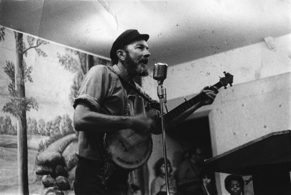 Pete Seeger with a banjo performing at a picnic, perhaps a fund-raising event, for the "Guardian," a radical weekly newspaper.