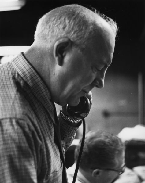 Candid photograph of journalist John T. "Jack" McManus speaking on the telephone. McManus was a writer for the "New York Times"; co-founder of the "National Guardian," a radical weekly newspaper; and two-time candidate for governor of New York on the American Labor Party.
