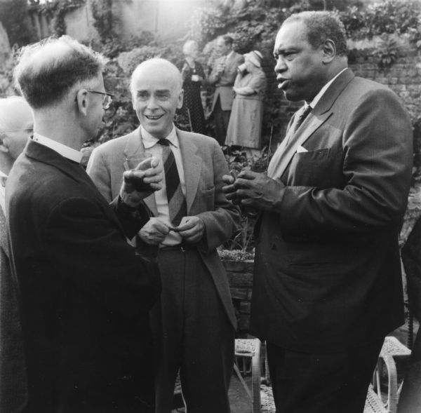 Cedric Belfrage (center), exiled editor of the "National Guardian," at a party for Paul Robeson. The man on the left is Canon Stanley Evans.