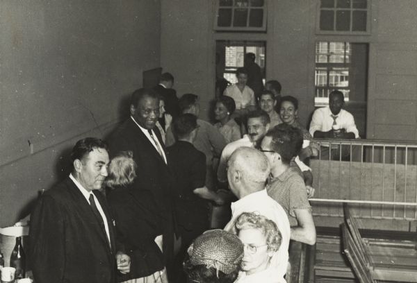 Farewell party for Cedric Belfrage of the "National Guardian" at the newspaper's office. Identified in the crowd is Paul Robeson, a longtime supporter of the paper, standing third from the left, and co-editor John T. McManus, the balding man in the center. Belfrage was being deported because of his refusal to testify to the McCarthy committee about alleged Communist associations.